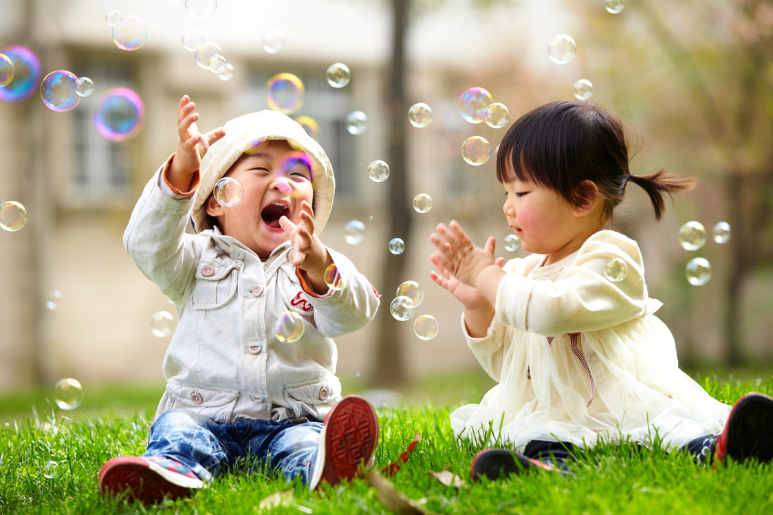 happy asian kids playing bubble together